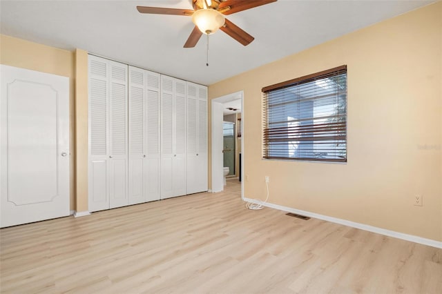 unfurnished bedroom with light wood-type flooring, a closet, and ceiling fan