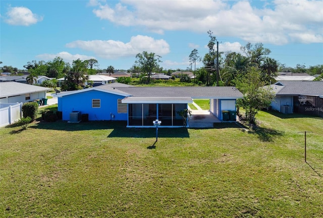 rear view of property with a sunroom, cooling unit, and a lawn