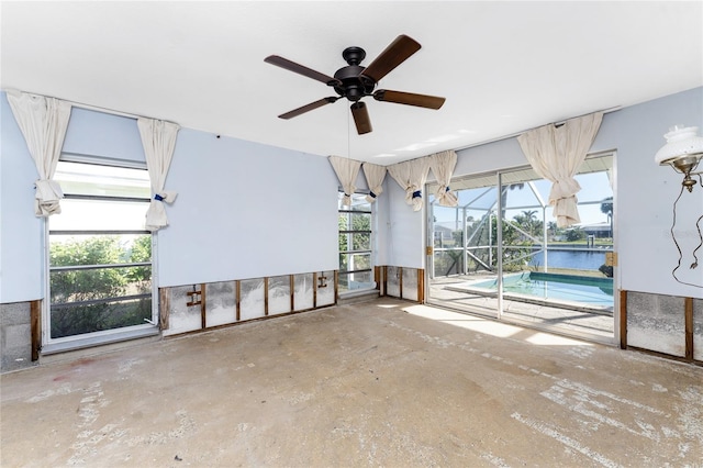 interior space featuring concrete floors, a water view, and ceiling fan