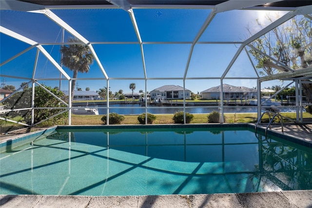 view of pool featuring glass enclosure and a water view