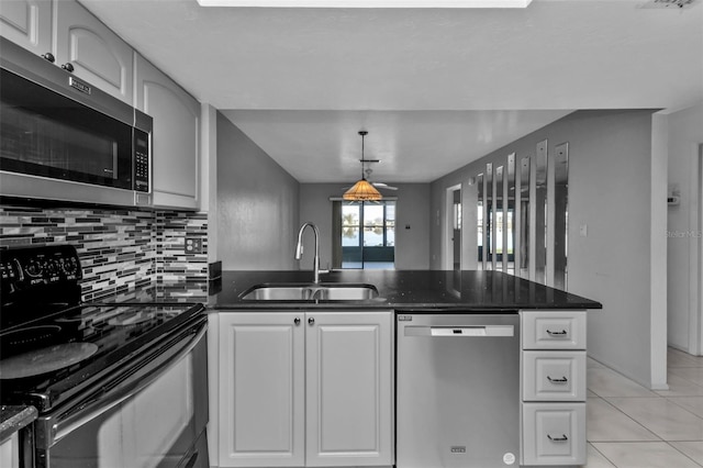 kitchen featuring white cabinetry, sink, tasteful backsplash, light tile patterned floors, and appliances with stainless steel finishes