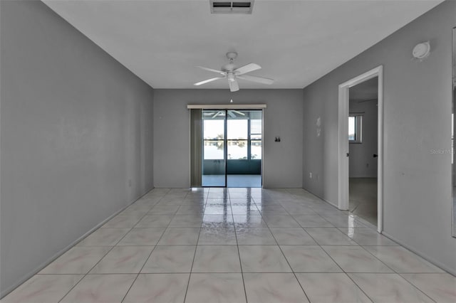 tiled spare room featuring ceiling fan