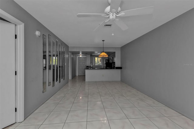 interior space with light tile patterned floors and ceiling fan