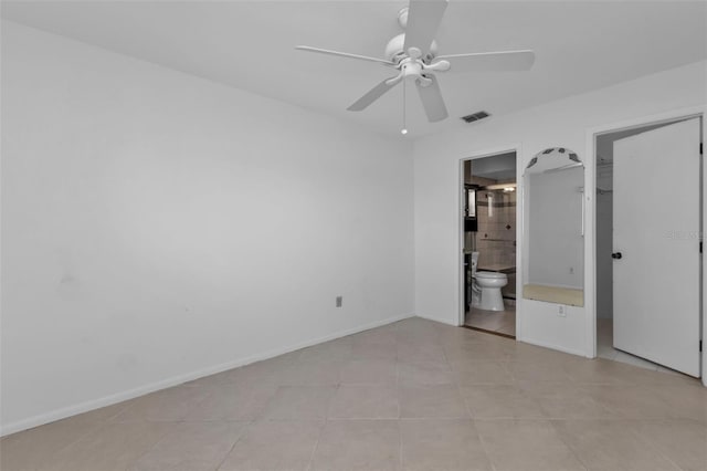 unfurnished bedroom with ensuite bath, ceiling fan, and light tile patterned floors