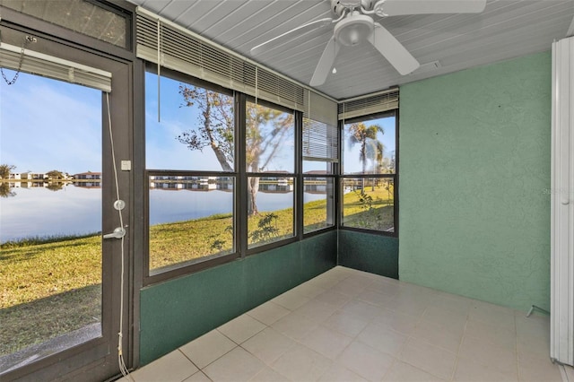 unfurnished sunroom featuring ceiling fan and a water view