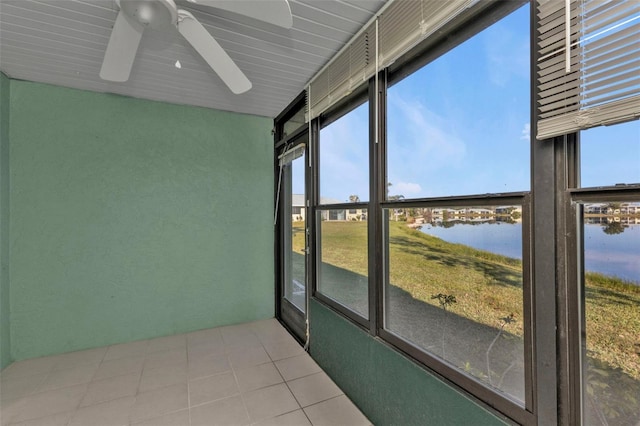 sunroom featuring ceiling fan and a water view