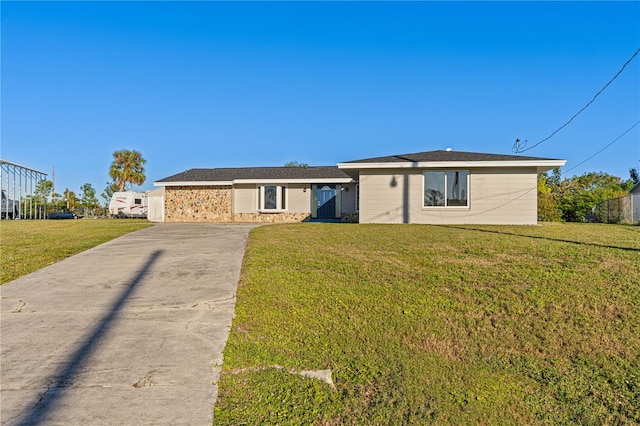 single story home with a front yard, concrete driveway, and stone siding