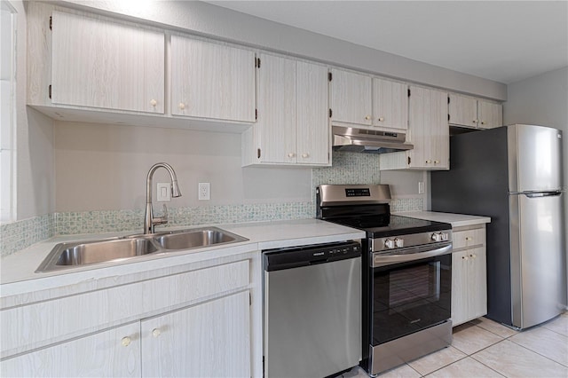 kitchen with backsplash, sink, light tile patterned floors, and stainless steel appliances