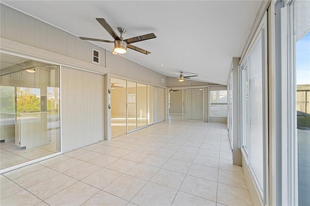 unfurnished sunroom with ceiling fan