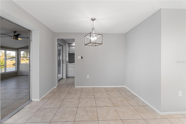 unfurnished dining area with ceiling fan with notable chandelier and light tile patterned floors