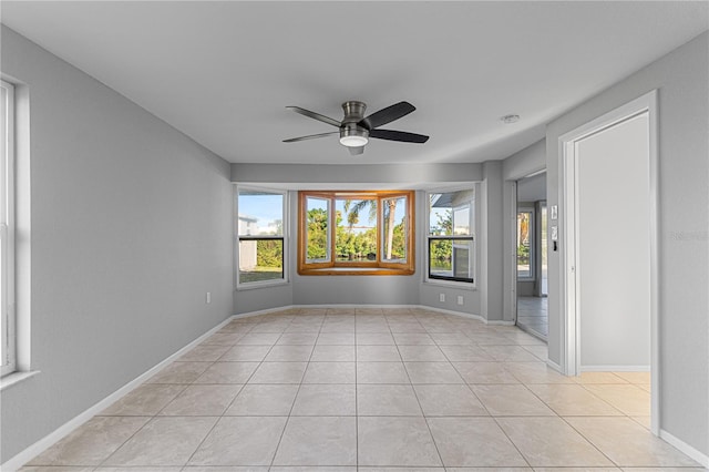 tiled empty room featuring ceiling fan