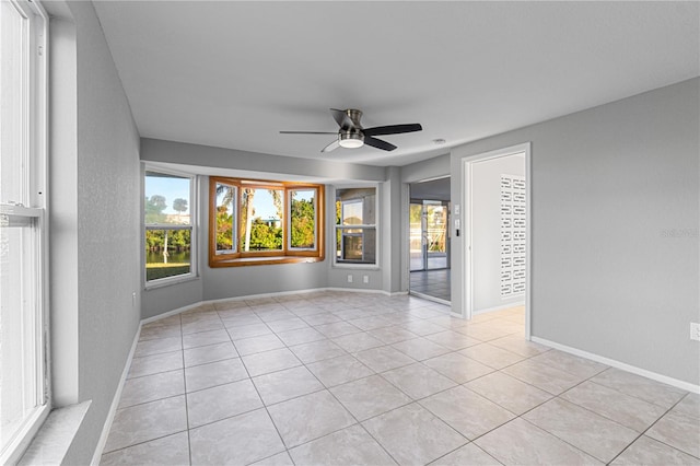 tiled empty room featuring ceiling fan