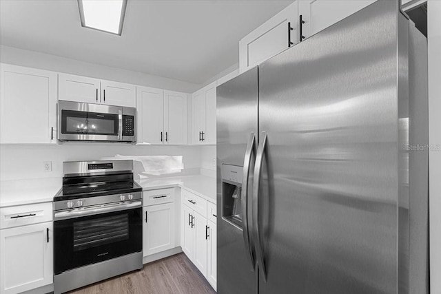 kitchen featuring white cabinetry, light hardwood / wood-style floors, and appliances with stainless steel finishes