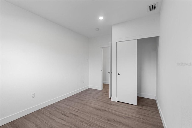 unfurnished bedroom featuring hardwood / wood-style floors and a closet