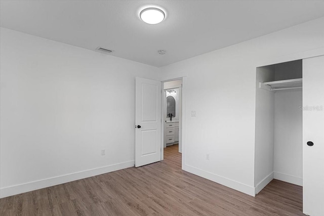 unfurnished bedroom featuring hardwood / wood-style floors and a closet