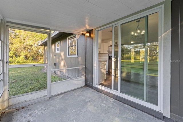 unfurnished sunroom with an inviting chandelier