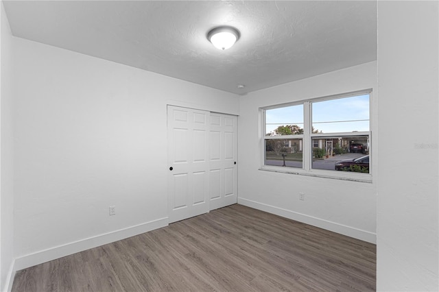 empty room with a textured ceiling and dark wood-type flooring