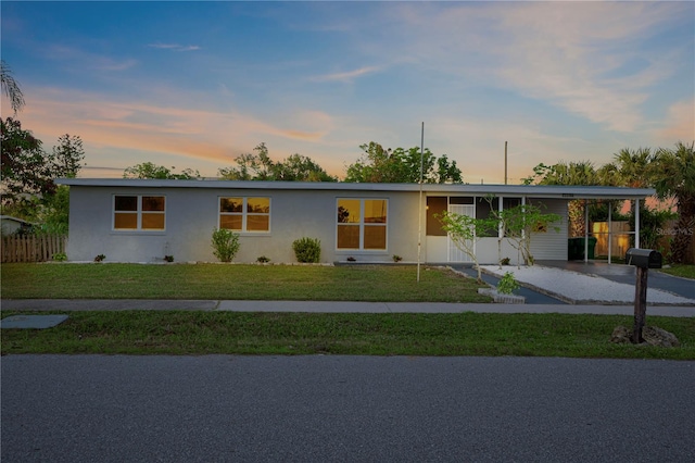 single story home featuring a carport and a yard