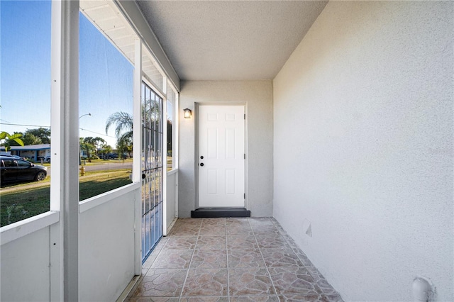 doorway to outside with a textured ceiling