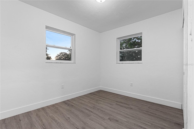 empty room featuring dark hardwood / wood-style flooring and a textured ceiling