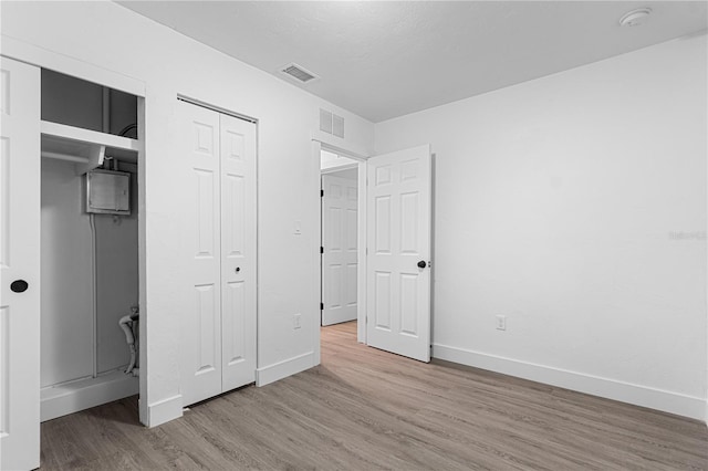 unfurnished bedroom featuring a closet and wood-type flooring