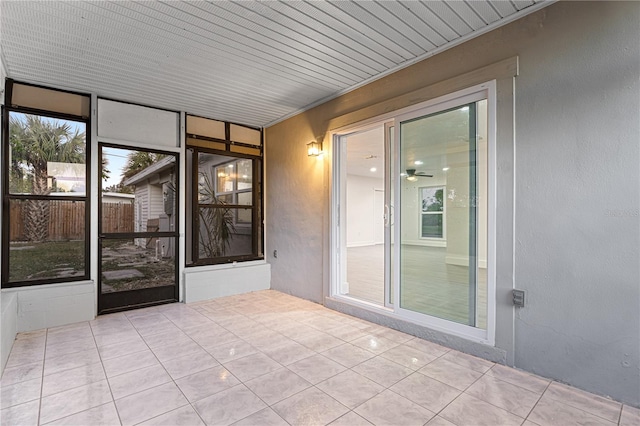 unfurnished sunroom featuring ceiling fan