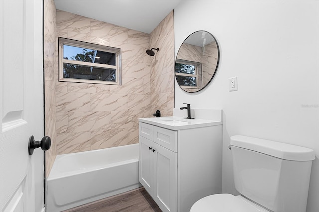 full bathroom with toilet, vanity, wood-type flooring, and tiled shower / bath