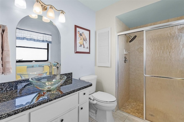 bathroom featuring tile patterned floors, toilet, vanity, and walk in shower