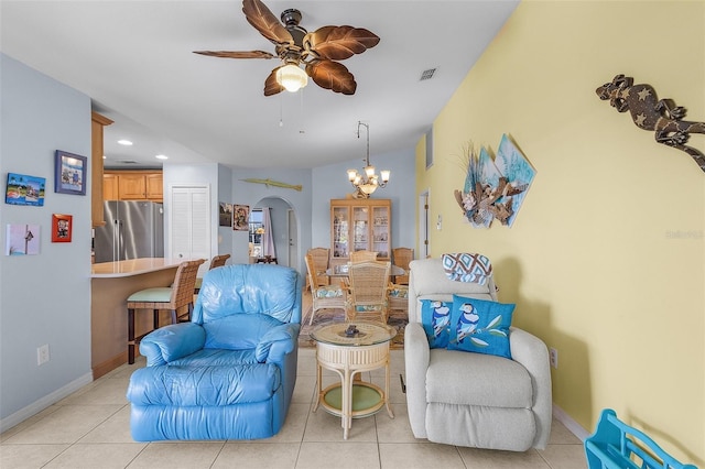 living area with light tile patterned floors and ceiling fan with notable chandelier