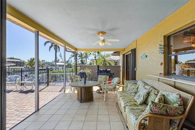 sunroom / solarium with a water view, a wealth of natural light, and ceiling fan