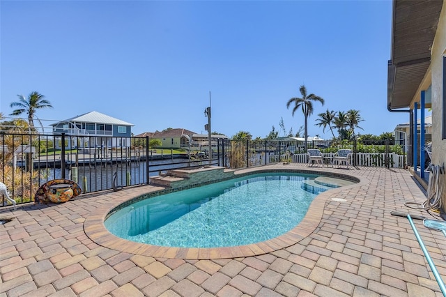 view of pool featuring a patio area, a water view, and a dock