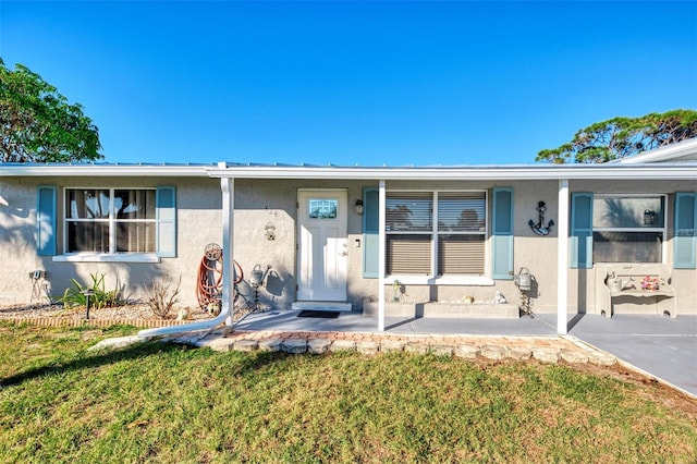 824 E 6th St, Englewood, FL 34223 - view of front of house with stucco siding, a front yard, and a porch
