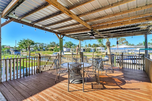 wooden deck with ceiling fan and a water view