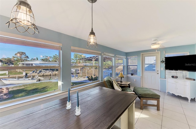 dining area with a water view, light tile patterned floors, and a chandelier