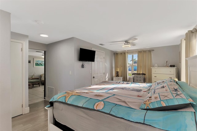 bedroom with ceiling fan, light wood-type flooring, and a closet