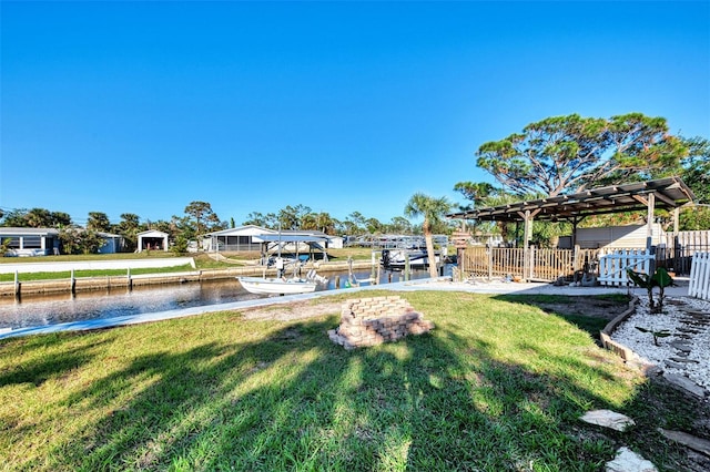 view of yard featuring a water view, a pergola, and a dock