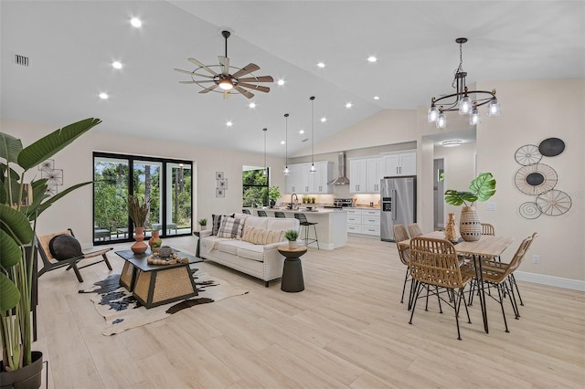 living room featuring sink, high vaulted ceiling, light hardwood / wood-style floors, and ceiling fan with notable chandelier