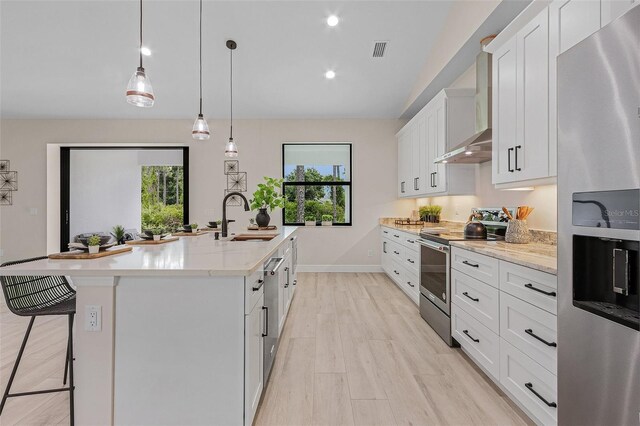 kitchen with white cabinets, sink, an island with sink, and appliances with stainless steel finishes