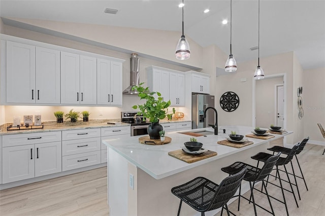 kitchen featuring white cabinetry, an island with sink, and vaulted ceiling