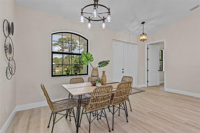 dining area with a chandelier and light hardwood / wood-style flooring