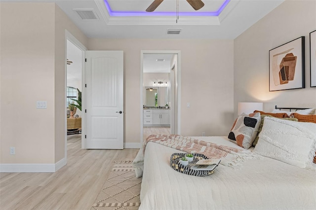 bedroom with connected bathroom, light hardwood / wood-style floors, and ceiling fan