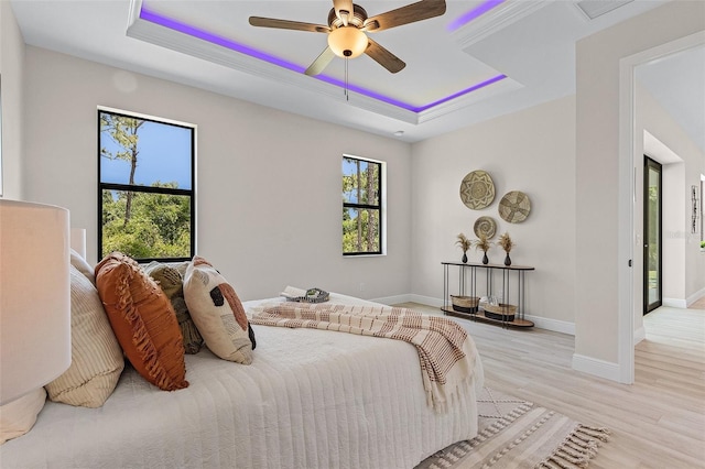 bedroom featuring a raised ceiling, ceiling fan, light hardwood / wood-style floors, and access to outside