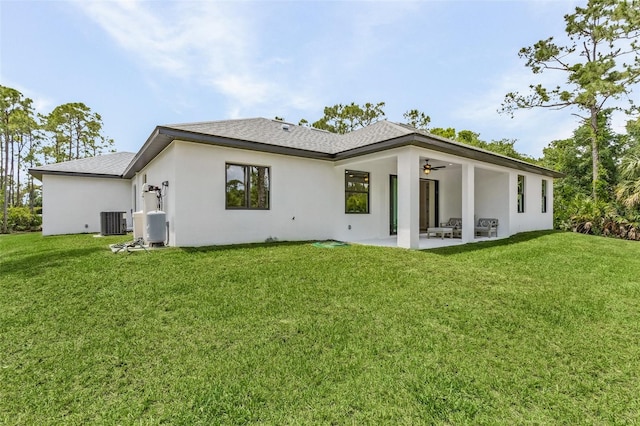 back of property featuring ceiling fan, a yard, cooling unit, and a patio