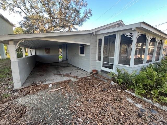 view of property exterior featuring a carport and a sunroom