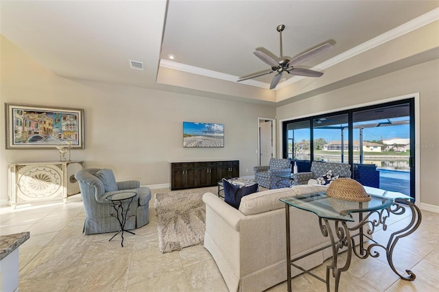 living room with a tray ceiling, ceiling fan, and ornamental molding