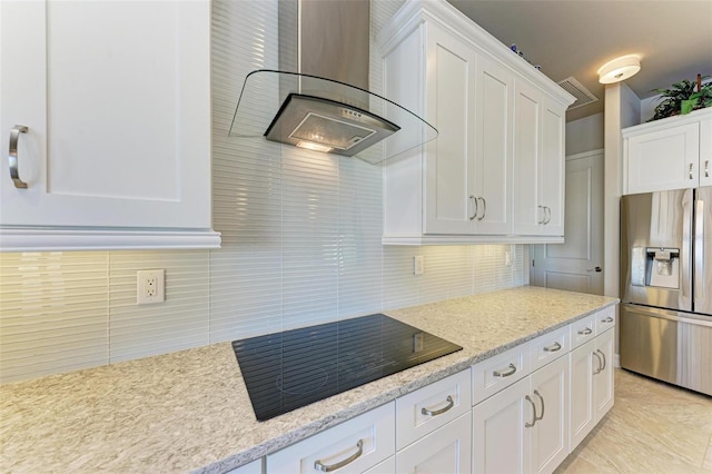 kitchen featuring decorative backsplash, black electric cooktop, wall chimney range hood, white cabinets, and stainless steel fridge with ice dispenser