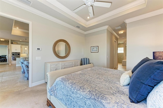 bedroom with ceiling fan, a raised ceiling, crown molding, and ensuite bath