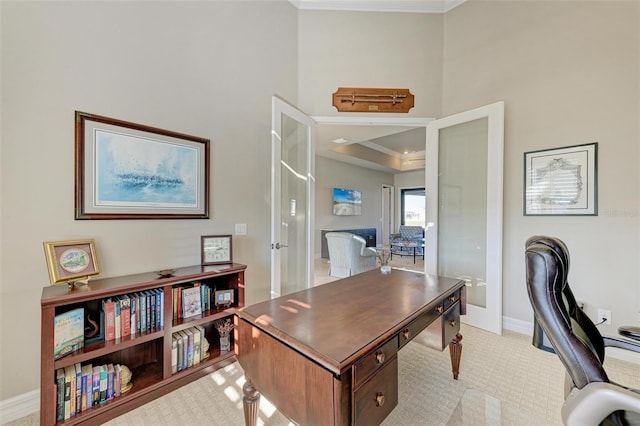 carpeted office space with a raised ceiling, french doors, and ornamental molding