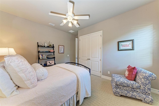 bedroom with ceiling fan, a closet, and light colored carpet