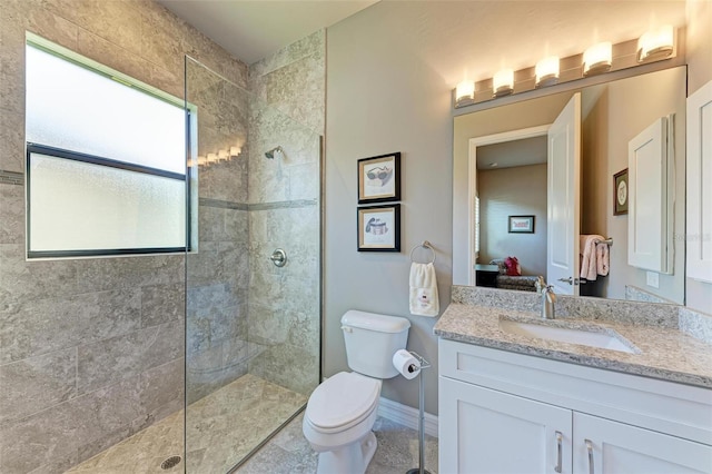 bathroom featuring vanity, toilet, and tiled shower